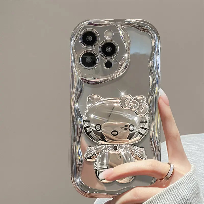 Silver phone case with a cat design held by a hand against a neutral background