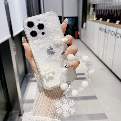 Person holding a phone with a clear case featuring snowflake designs, in an indoor setting.