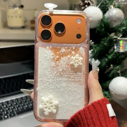 Phone case with snowflake design held by a person in front of a Christmas tree.