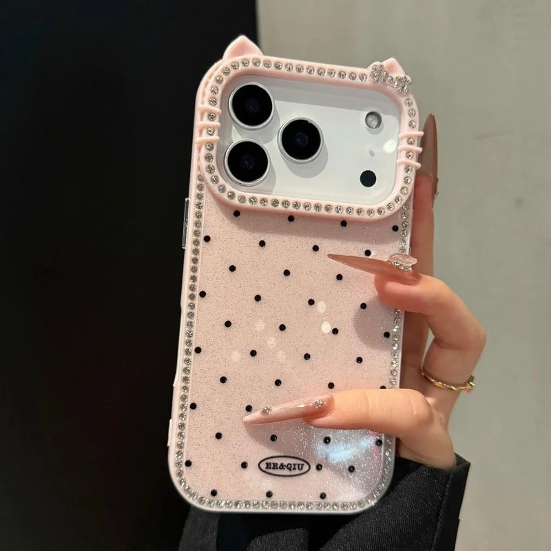 Phone case with polka dots and rhinestones held by a hand